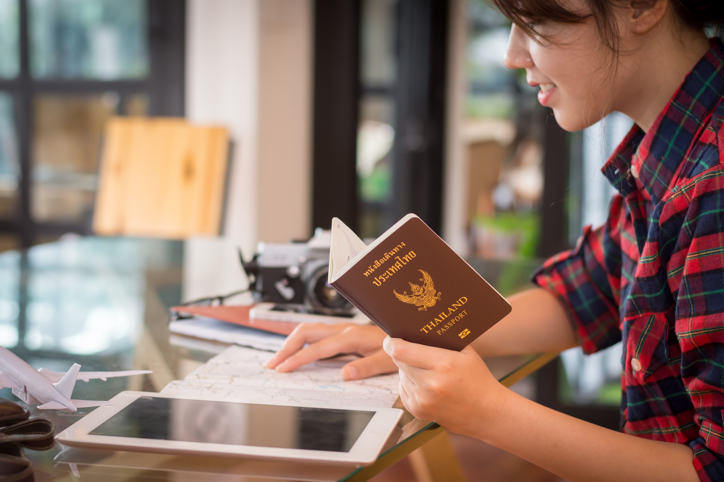 Female tourist holding a passport while reading a map