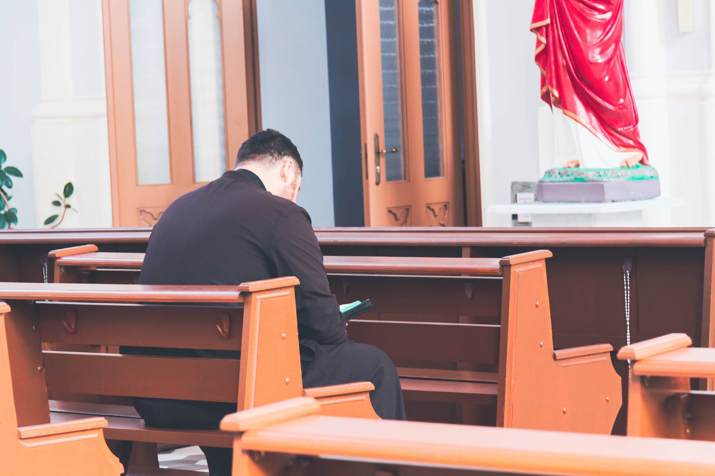 Person Praying Inside The Church